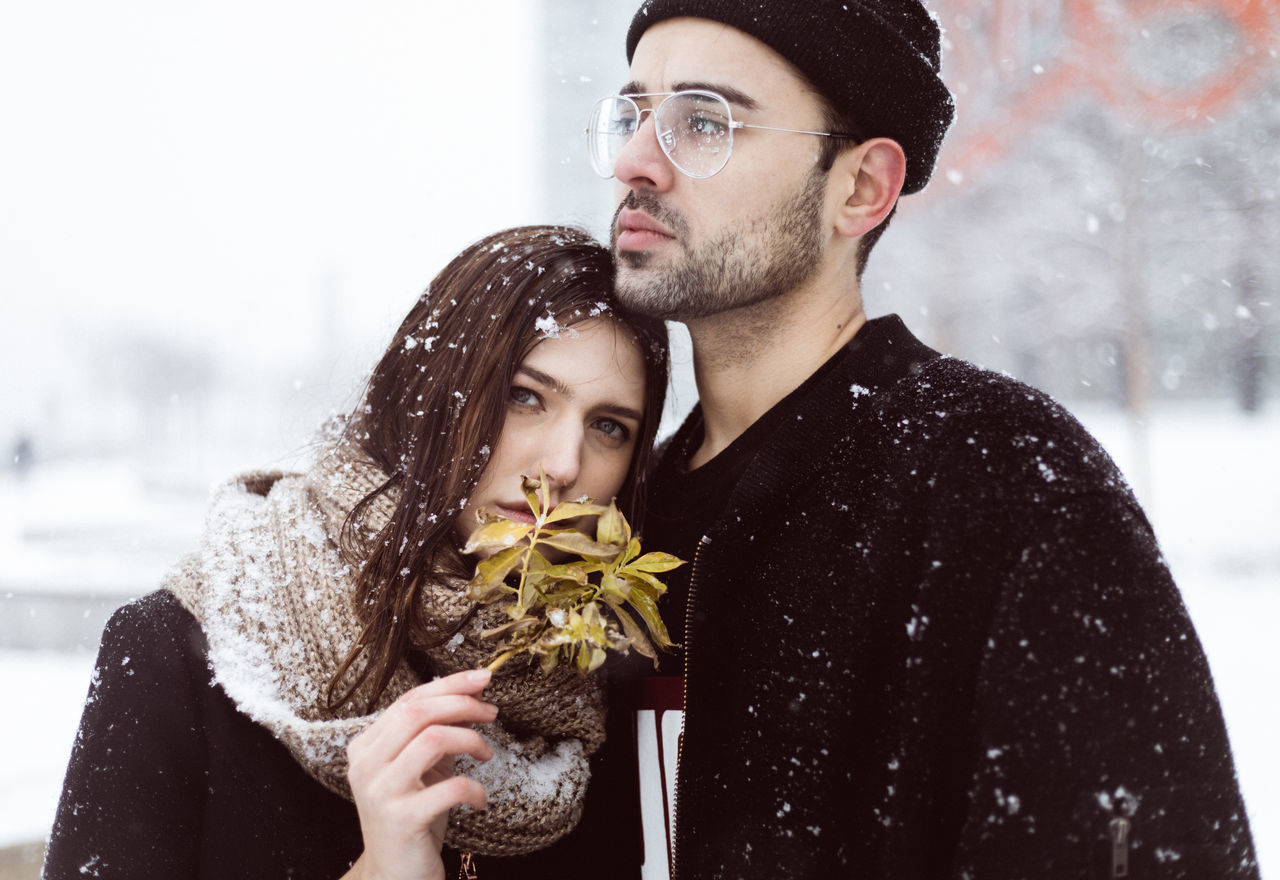 winter, warm clothing, young adult, two people, young women, cold temperature, snow, young men, real people, togetherness, lifestyles, celebration, holding, christmas, outdoors, day, standing, snowing, close-up, snowflake, city, adults only, adult, people