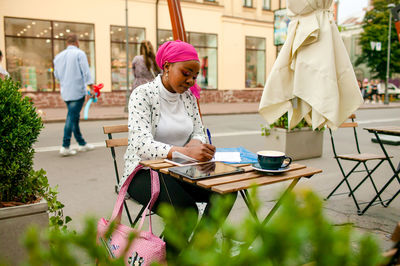 Young african muslim woman working in outdoor cafe