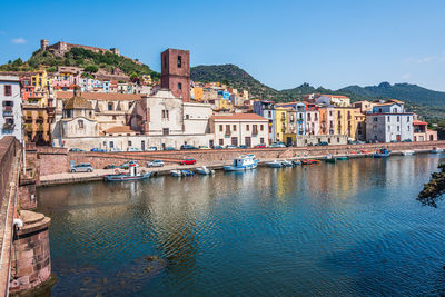 Buildings in city against clear blue sky