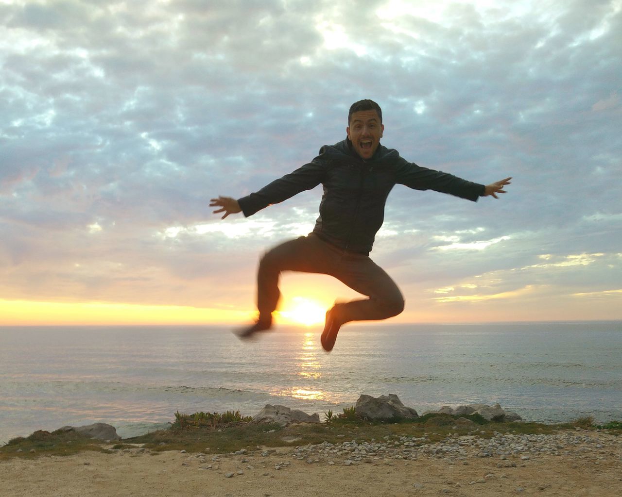 sky, full length, sea, leisure activity, water, sunset, lifestyles, cloud - sky, horizon over water, beach, arms outstretched, mid-air, shore, fun, tranquil scene, enjoyment, vacations, scenics