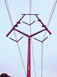 Low angle view of electricity pylon against clear sky