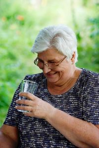 Smiling senior woman holding drinking glass