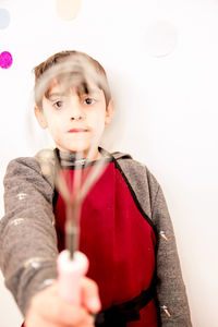 Close-up of boy holding wire whisk