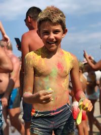 Full length of shirtless boy standing against blurred background