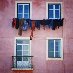 Pink house with multicoloured washing and symmetrical window layout