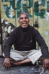 Portrait of smiling man sitting outdoors