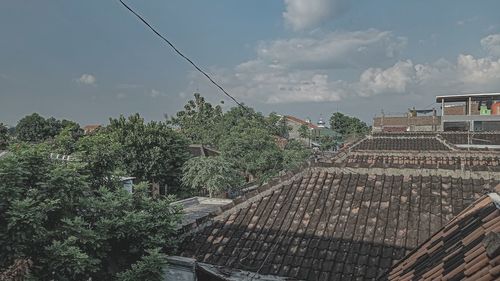 High angle view of roof and trees against sky