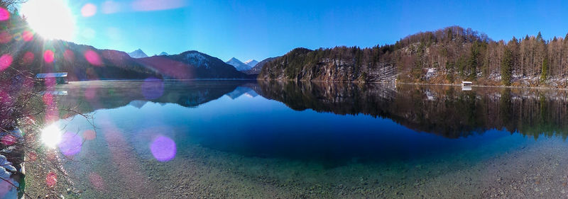 Scenic view of lake and mountains against blue sky