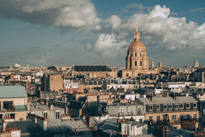 Buildings in city against cloudy sky