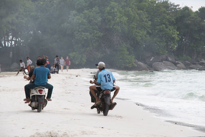 Cambodians driving a bike on the beach