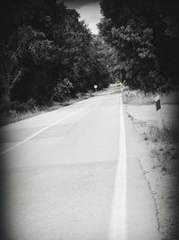 Road amidst trees against sky