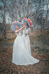 Woman with umbrella standing on land