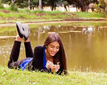 Portrait of smiling young woman using mobile phone in grass