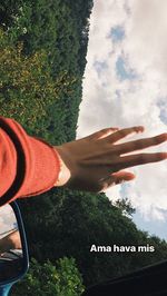 Midsection of person holding umbrella against sky