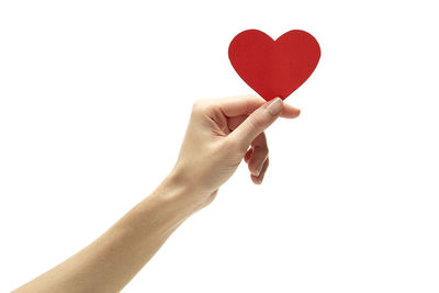 Close-up of hand holding heart shape against white background
