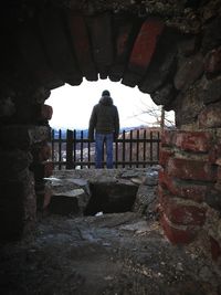 Rear view of man standing by wall