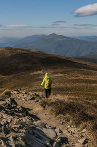 Rear view of man walking on mountain road