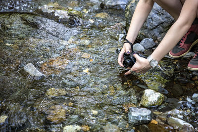 Low section of woman standing on rock