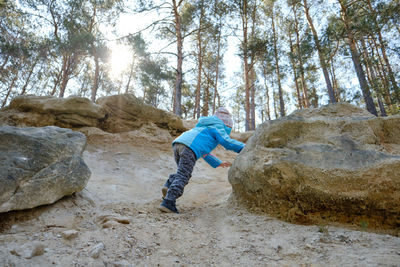 Side view of man on rock in forest