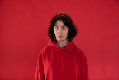 Portrait of a teenage girl against red background