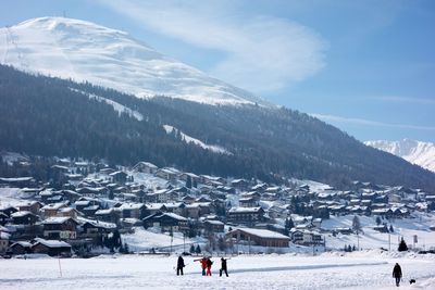 People on snow covered mountains against sky