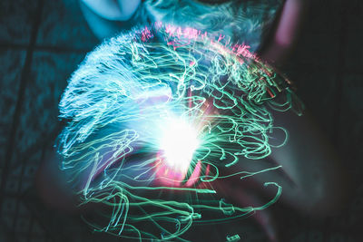 Double exposure of illuminated plasma ball and woman