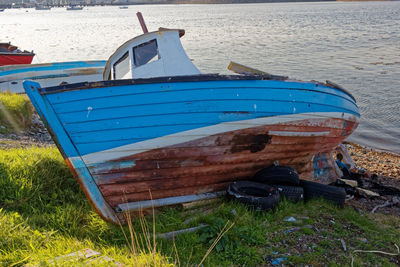 Boat moored on beach by sea