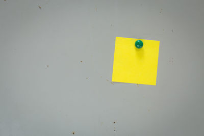 Close-up of yellow paper on wall