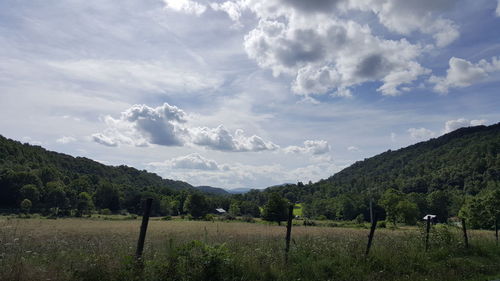 Scenic view of field against cloudy sky