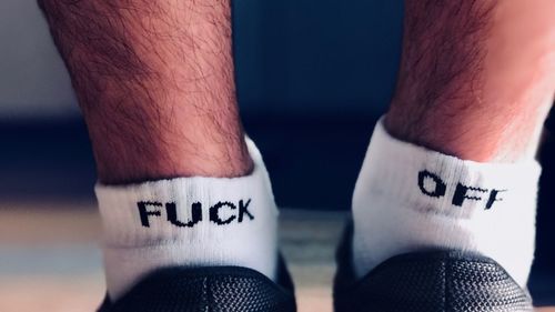 Low section of man wearing socks with text