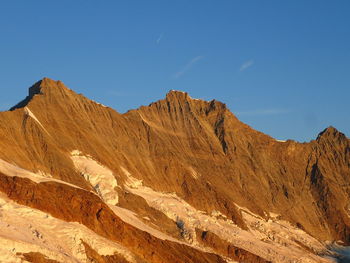 Scenic view of mountains against clear blue sky