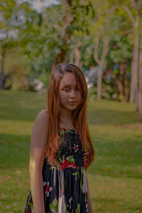 Portrait of young woman standing against plants