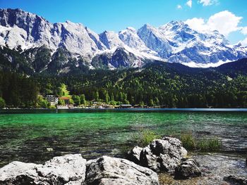 Scenic view of lake by mountains against sky