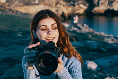 Portrait of young woman photographing