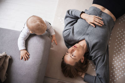 High angle view of young woman lying on bed at home