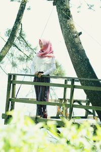 Low angle view of woman standing by railing