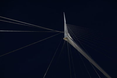 Low angle view of suspension bridge against sky at night