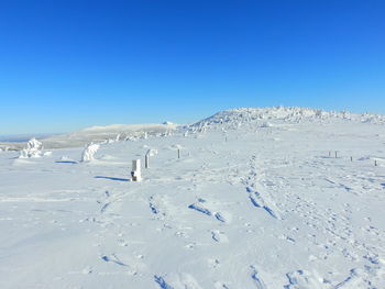 Scenic view of snowcapped mountains against clear blue sky