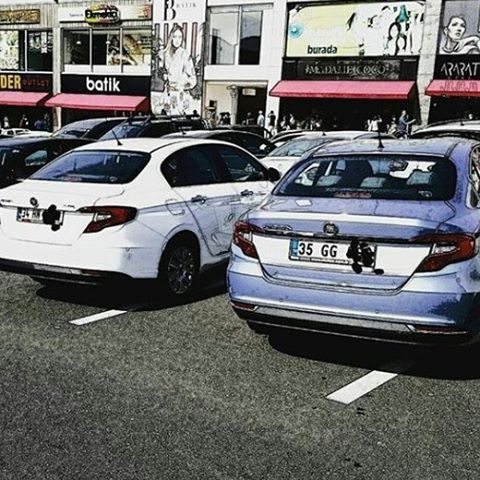 transportation, mode of transport, car, land vehicle, street, city, building exterior, architecture, road, built structure, travel, stationary, road marking, parking, traffic, outdoors, parking lot, city life, day, city street