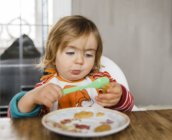 Cute girl eating food at home