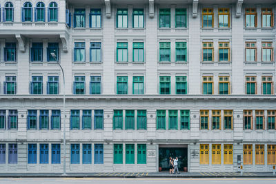 People walking by building in city