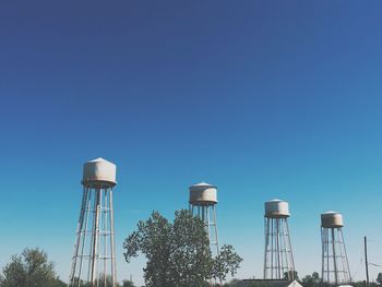 Low angle view of water tower against clear blue sky