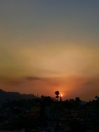 Silhouette buildings against sky during sunset