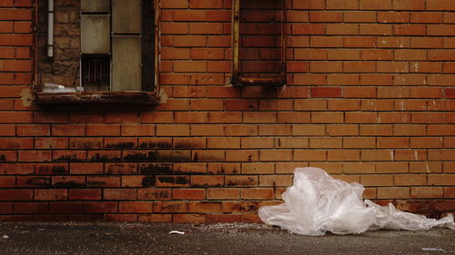 Garbage can on brick wall of building