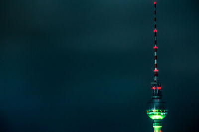 Illuminated fernsehturm against sky at night