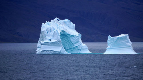 Scenic view of sea against snowcapped mountain