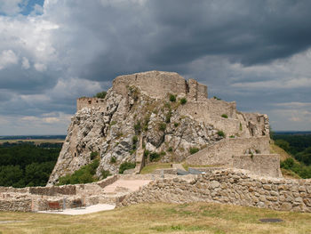 Rock formations with a ruined castle on landscape against sky