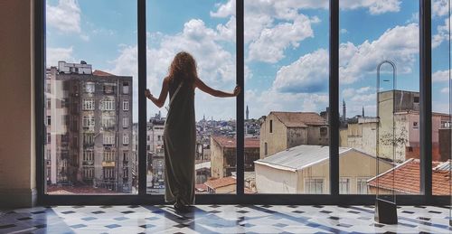 Woman standing by window in city