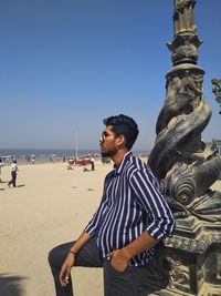 Man standing at beach against clear sky in mumbai waiting for his time.