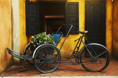 Tricyele and potted plant on bicycle outside house in vietnam